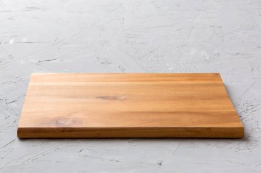 Çimento arka planında tahta kesme tahtası manzarası. Tasarımın için boş boşluk.