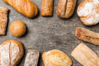 Ev yapımı doğal ekmek. Arka plan olarak farklı taze ekmek türleri, kopya alanı ile üst görünüm.
