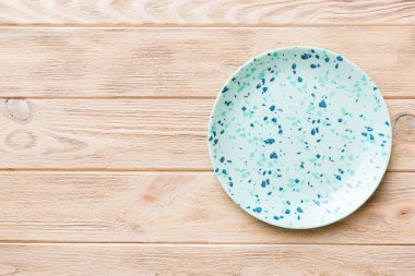 Ahşap zemindeki boş mavi tabağın üst görüntüsü. Tasarımın için boş boşluk.