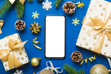 Digital phone mock up with rustic Christmas decorations for app presentation top view with empty space for you design. Christmas online shopping concept. Tablet with copy space on colored background.