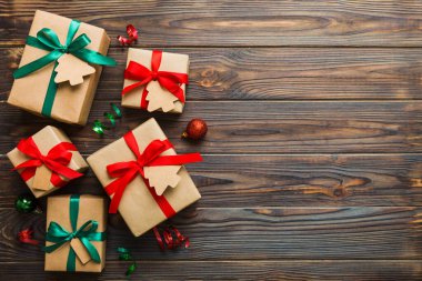 wrapped christmas or other holiday handmade present in paper with colored ribbon. Present box, decoration of gift on colourfull table, top view with copy space.