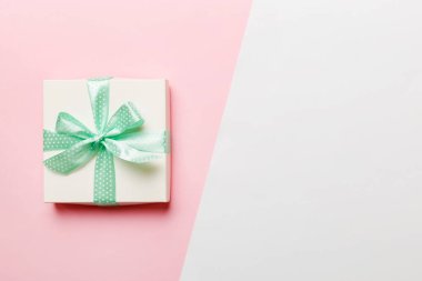 Tatil el yapımı beyaz hediye yeşil kurdeleli üst görünümü fotokopi alanı ile birleştirdi. Tatil geçmişi düzdü. Doğum günü ya da Noel hediyesi. Kopya alanı olan Noel hediyesi kutusu konsepti.