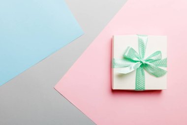 holiday handmade white present tied green ribbon bow top view with copy space. Flat lay holiday background. Birthday or christmas present. Christmas gift box concept with copy space.