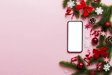 Digital phone mock up with rustic Christmas decorations for app presentation top view with empty space for you design. Christmas online shopping concept. Tablet with copy space on colored background.