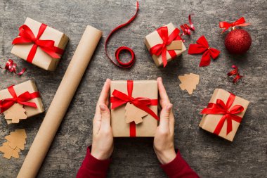 Kadın eli hediye kutusunu tutuyor, sürprizi hazırlıyor, üst manzara, Noel ve yeni yıl konsepti.