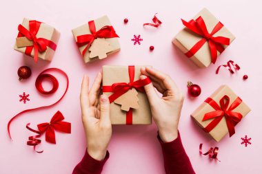 Kadın eli hediye kutusunu tutuyor, sürprizi hazırlıyor, üst manzara, Noel ve yeni yıl konsepti.