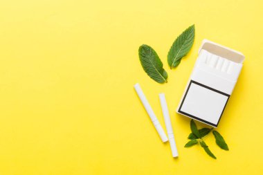 Bir paket mentollü sigara ve renkli masada taze nane şekeri, mentollü sigaralar düz yerde yatıyordu..