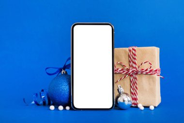Digital phone mock up with rustic Christmas decorations for app presentation with empty space for you design. Christmas online shopping concept. Tablet with copy space on colored background.