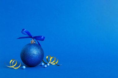 Christmas ball on colored background. decoration bauble with ribbon bow with copy space.