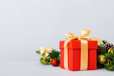 New Year Christmas mood, gift box, branches of a christmas tree, New Year decorations on a colored background.