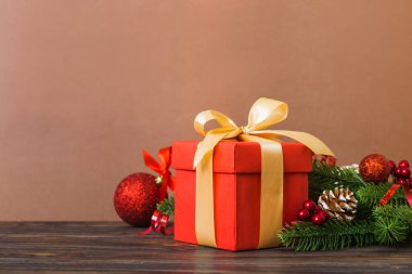 New Year Christmas mood, gift box, branches of a christmas tree, New Year decorations on a colored background.