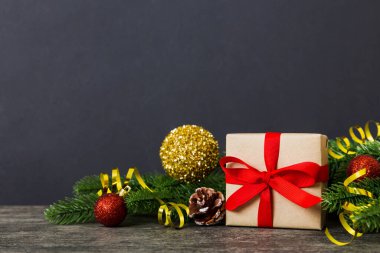 New Year Christmas mood, gift box, branches of a christmas tree, New Year decorations on a colored background.