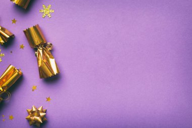 Renkli arka planda parlak konfetileri olan Noel krakerleri, üst görünüm, boşluk kopyala.