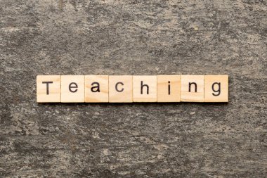 Tahta bloğa yazılmış bir kelime. Deksing, konsept için çimento masa üzerinde metin öğretme.