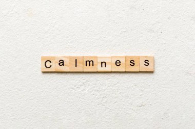 Tahta blokta sakinlik kelimesi yazılı. Çimento masasındaki sakinlik metni desing, konsept için.