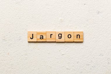 Ahşap blokta Jargon kelimesi yazıyor. Üst görünüm konseptiniz için çimento masadaki Jargon metni.