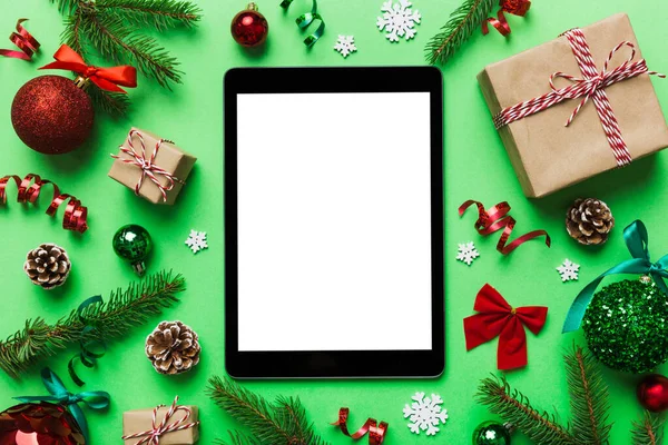 Digital tablet mock up with rustic Christmas decorations for app presentation top view with empty space for you design. Christmas online shopping concept. Tablet with copy space on colored background.