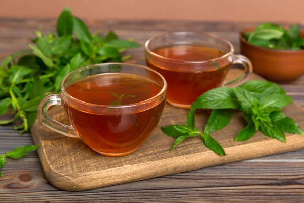 Cup of mint tea on table background. Green tea with fresh mint top view with copy space.