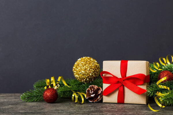 Новогоднее настроение, подарочная коробка, ветви елки, новогодние украшения на цветном фоне.