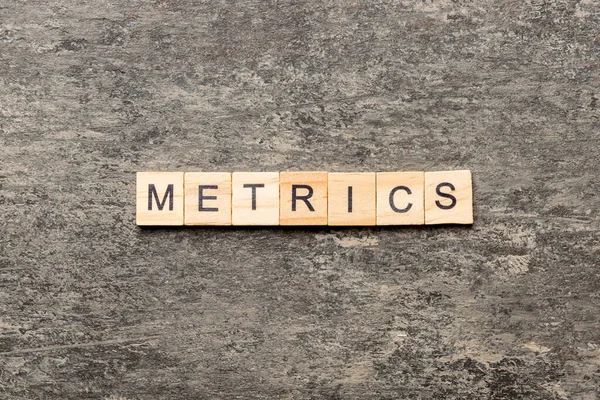 Metrics Palabra Escrita Bloque Madera Metrics Texto Sobre Tabla Cemento —  Fotos de Stock