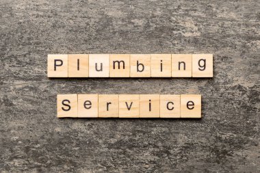 Tesisat servisi kelimesi ahşap blokta yazılı. Tesisat servisi metni çimento masasında desing, konsept için.