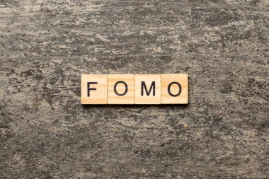 Tahta blokta yazılı bir kelime. fomo metin masa üzerinde, konsept.