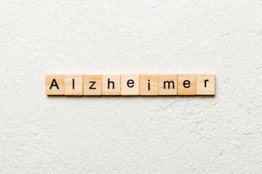 Tahta blokta Alzheimer kelimesi yazıyor. Alzheimer metni çimento masasında desing, konsept için.