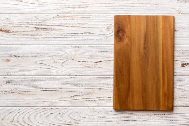 Çimento arka planında ahşap kesim tahtasının üst görüntüsü. Tasarımın için boş boşluk.