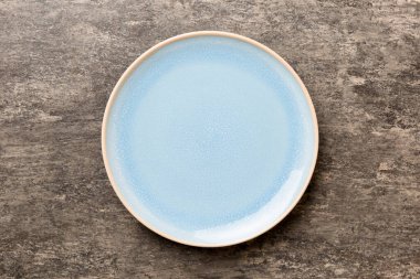 Beton zemin üzerinde boş mavi plaka üst görünümü. Tasarımın için boş boşluk.