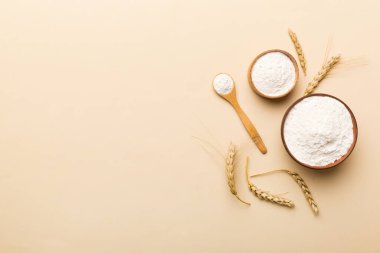 Tahta kasede buğday unu ve renkli arka planda buğday dikenleri. dünya buğday krizi.