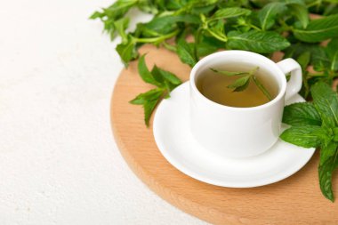 Arka planda bir fincan nane çayı. Fotokopi alanı ile taze nane görünümlü yeşil çay.