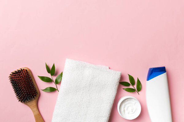 косметика для ухода за волосами, кремом и полотенцем на цветном фоне вид сверху. Плоская постель.