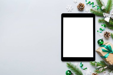 Digital tablet mock up with rustic Christmas decorations for app presentation top view with empty space for you design. Christmas online shopping concept. Tablet with copy space on colored background.