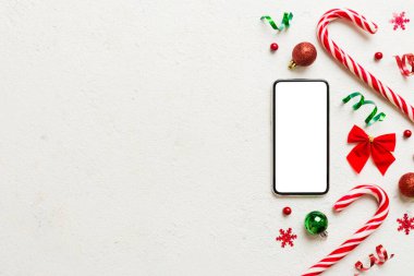 Digital phone mock up with rustic Christmas decorations for app presentation top view with empty space for you design. Christmas online shopping concept. Tablet with copy space on colored background.