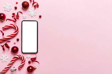Digital phone mock up with rustic Christmas decorations for app presentation top view with empty space for you design. Christmas online shopping concept. Tablet with copy space on colored background.