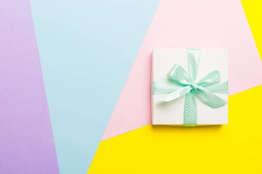 Tatil el yapımı beyaz hediye yeşil kurdeleli üst görünümü fotokopi alanı ile birleştirdi. Tatil geçmişi düzdü. Doğum günü ya da Noel hediyesi. Kopya alanı olan Noel hediyesi kutusu konsepti.