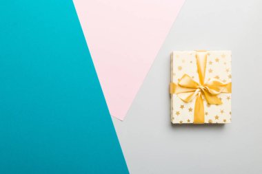 holiday paper present tied yellow ribbon bow top view with copy space. Flat lay holiday background. Birthday or christmas present. Christmas gift box concept with copy space.