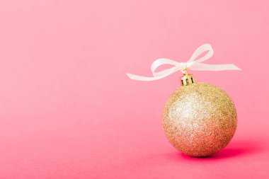 Christmas ball on colored background. decoration bauble with ribbon bow with copy space.
