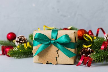New Year Christmas mood, gift box, branches of a christmas tree, New Year decorations on a colored background.