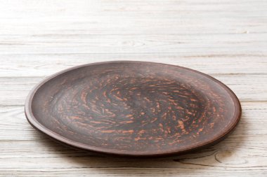 Ahşap zemindeki boş tabağın perspektif görüntüsü. Tasarımın için boş boşluk.