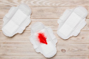 Kadın hijyen ürünleri ya da arka planda kırmızı tüy olan hijyenik ped. Pastel renk. - Yakın çekim. Mesaj için boş bir yer. Kadın günlük hijyeni..