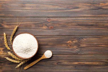 Tahta kasede buğday unu ve renkli arka planda buğday dikenleri. dünya buğday krizi.