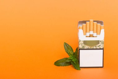 Bir paket mentollü sigara ve renkli masada taze nane şekeri, mentollü sigaralar düz yerde yatıyordu..