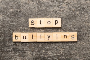 Ahşap blokta yazan sözlere sataşmayı bırak. Çimento masasında sataşmayı bırak, konsept.