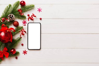 Digital phone mock up with rustic Christmas decorations for app presentation top view with empty space for you design. Christmas online shopping concept. Tablet with copy space on colored background.