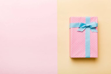 holiday handmade paper present tied blue ribbon bow top view with copy space. Flat lay holiday background. Birthday or christmas present. Christmas gift box concept with copy space.