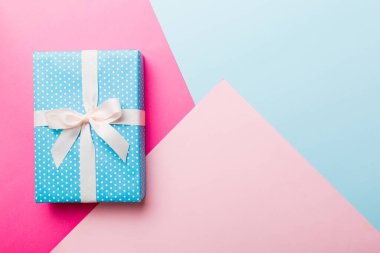 holiday handmade paper present tied white ribbon bow top view with copy space. Flat lay holiday background. Birthday or christmas present. Christmas gift box concept with copy space.