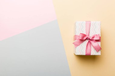 holiday paper present tied pink ribbon bow top view with copy space. Flat lay holiday background. Birthday or christmas present. Christmas gift box concept with copy space.