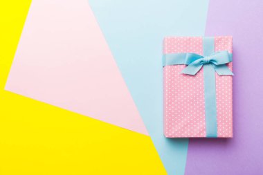 holiday handmade paper present tied blue ribbon bow top view with copy space. Flat lay holiday background. Birthday or christmas present. Christmas gift box concept with copy space.