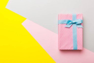 holiday handmade paper present tied blue ribbon bow top view with copy space. Flat lay holiday background. Birthday or christmas present. Christmas gift box concept with copy space.